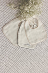 Edged white/blush muslin bib by Lilette